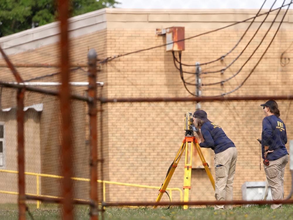Members of the FBI's Evidence Response Team work near the building from which a gunman attempted to assassinate Republican presidential candidate Donald Trump.