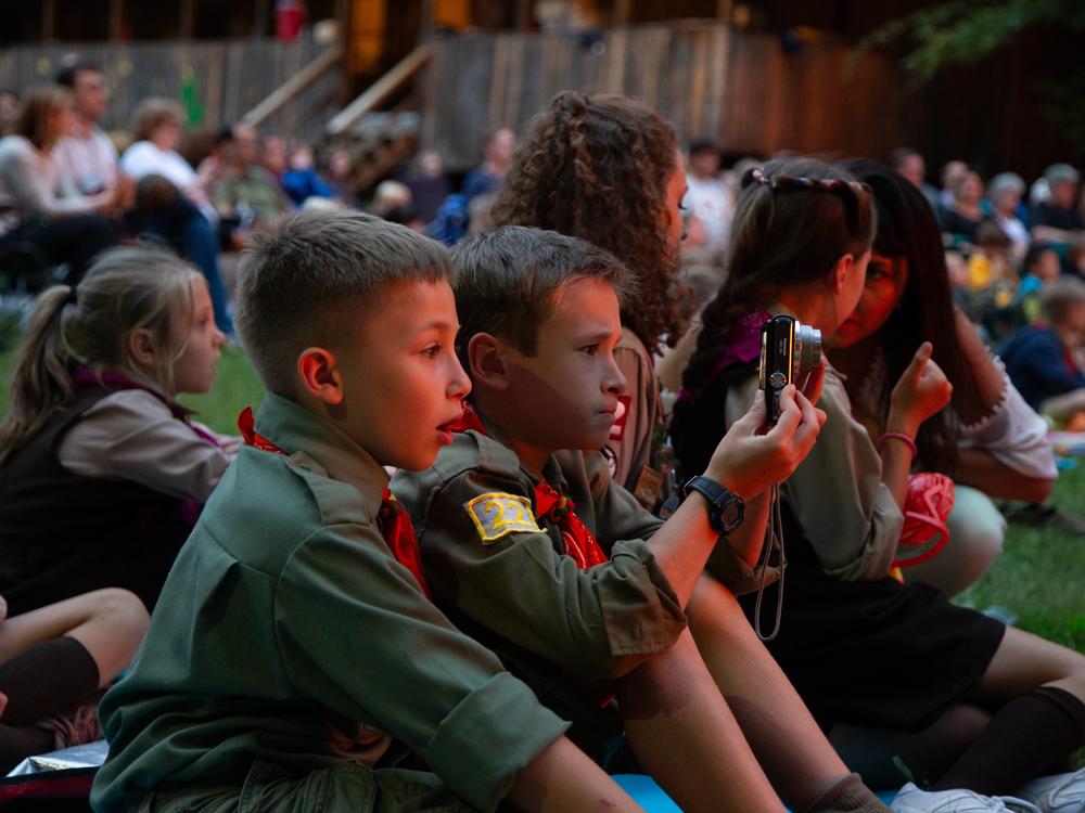 Two young <em>novaky</em>, male campers ages 6-11, look on in awe at the huge bonfire created every year for parents' weekend.