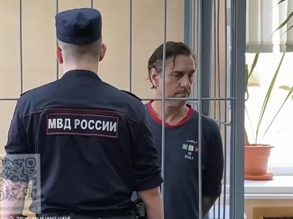 In this photo taken from video released by Khamovnichesky District Court press service on Thursday, U.S. citizen Michael Travis Leake stands in a cage in a Moscow courtroom before being convicted of drug trafficking charges and sentenced to 13 years in prison.