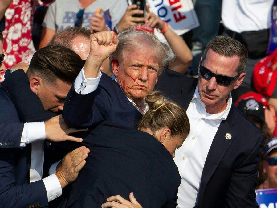 Republican candidate Donald Trump is surrounded by Secret Service agents following an attempted assassination attempt in in Butler, Pa., on July 13. The head of the Secret Service will appear before lawmakers Monday to discuss the agency's actions before, during and after the incident.