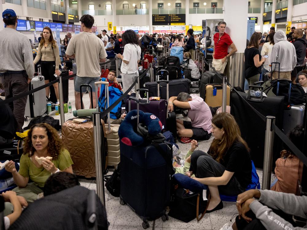 Passengers line up at London's Gatwick Airport amid a global IT outage on Friday.  