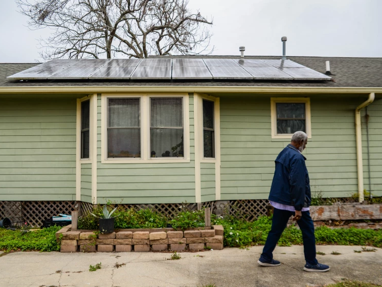 Rev. Charles Duplessis walks by his solar panel-topped house in New Orleans' Lower Ninth Ward neighborhood on Friday, Feb. 25, 2022. The Environmental Protection Agency this week awarded the city nearly $50 million to help pay for installing solar on low to middle income homes.