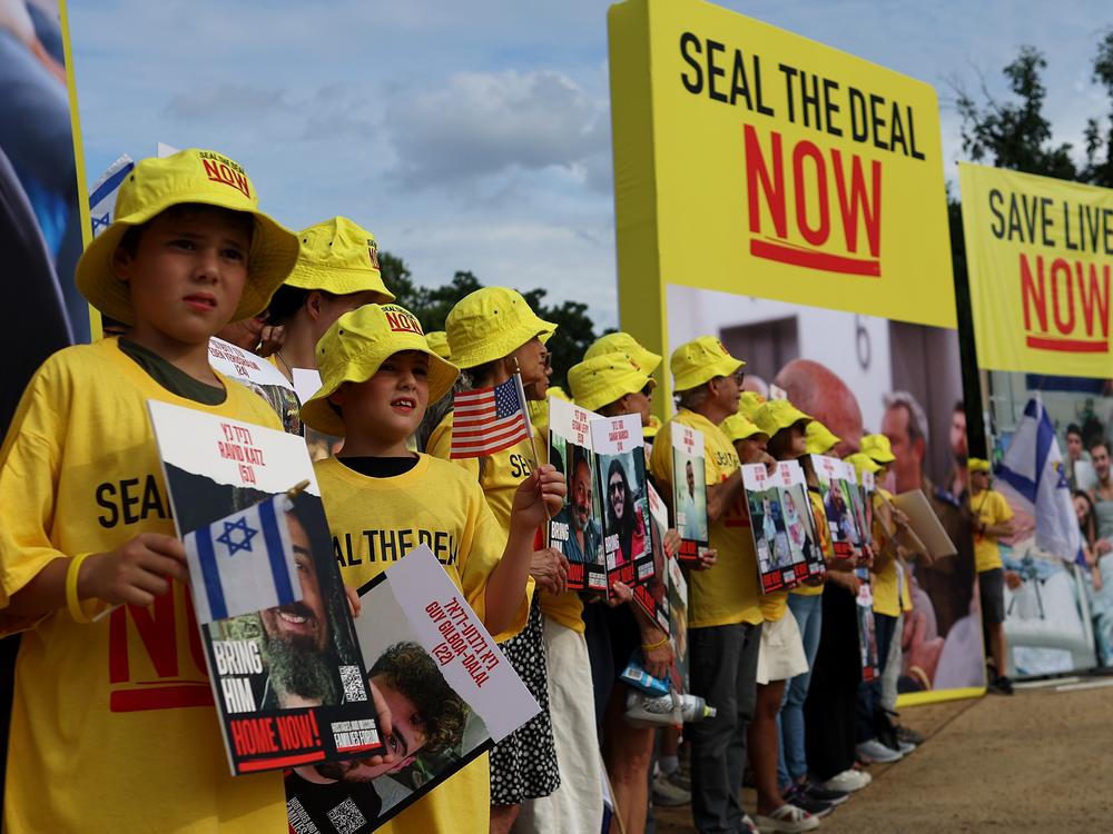 People hold pictures of Israeli hostages during a vigil on the National Mall on Tuesday in Washington, D.C. Families of hostages are hopeful Israeli Prime Minister Netanyahu will agree to a ceasefire deal that would bring the hostages home.