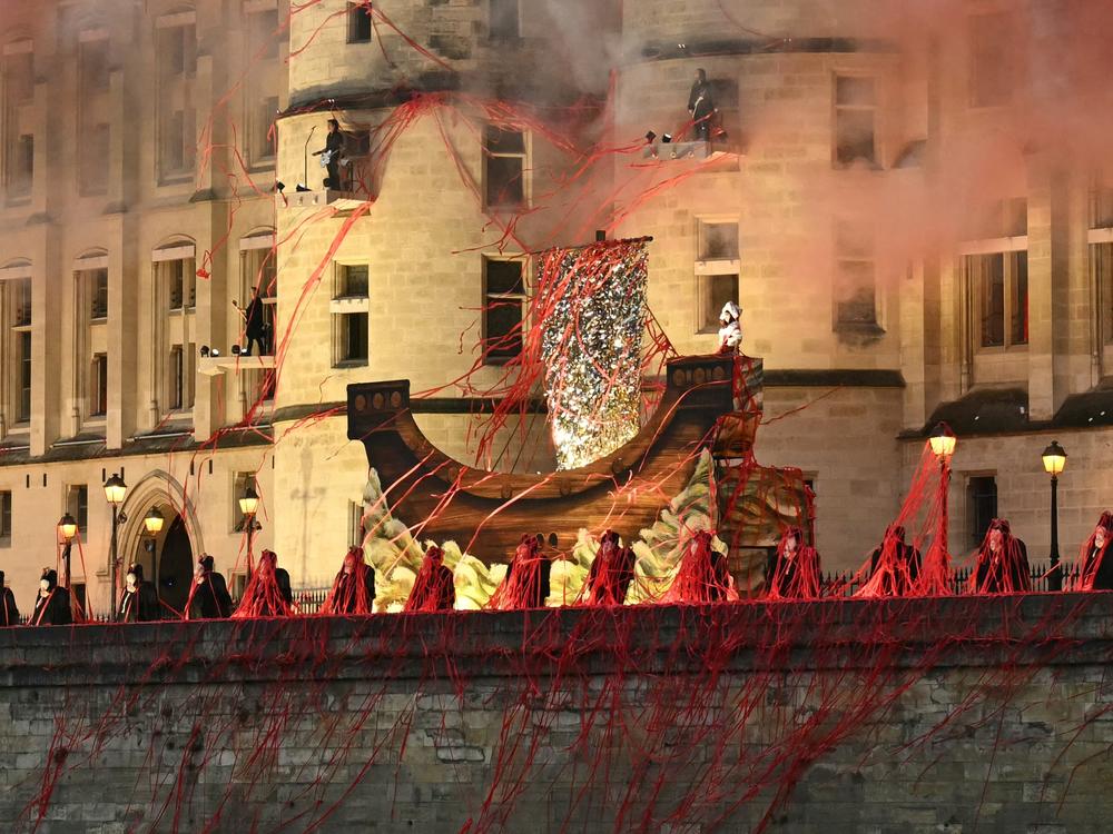 Headless figures depicting the 18th century Queen Marie Antoinette perform along the Seine river embankment outside the Conciergerie, where the queen was held captive during the French revolution, during the Paris 2024 Olympics opening ceremony on July 26, 2024.