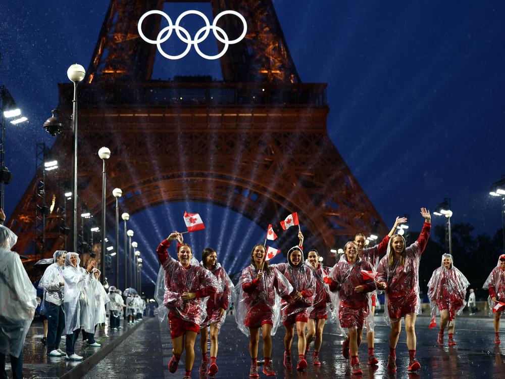 Athletes of Canada wave their flags after arriving at the Trocadero during the opening ceremony.