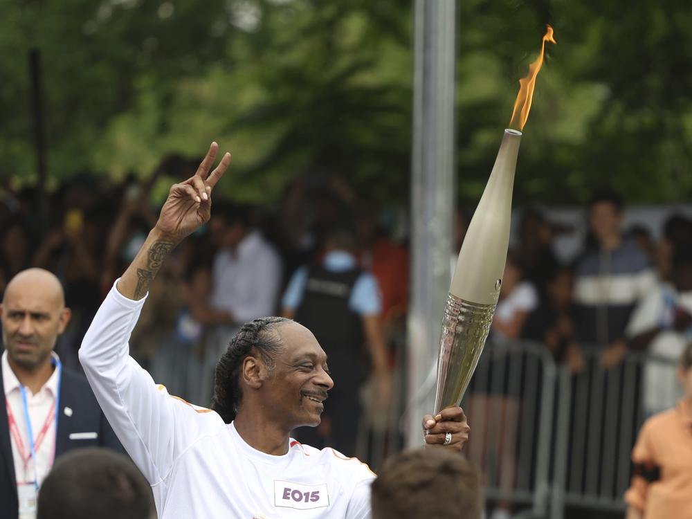 Snoop Dogg carries the Olympic torch.