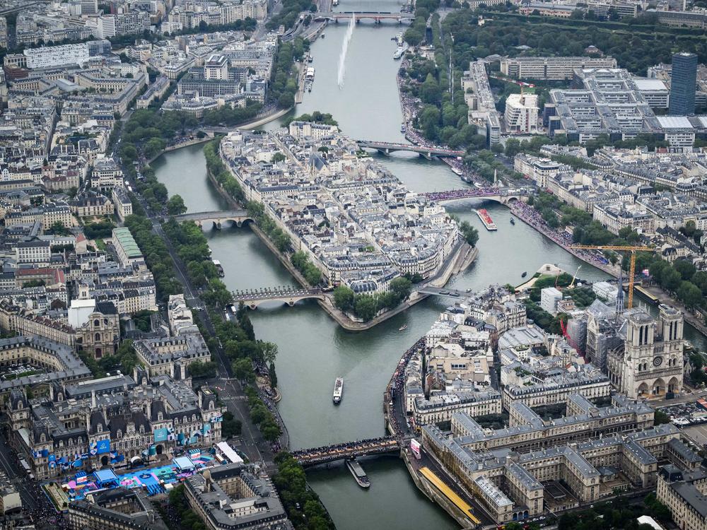 Delegations boats navigate on the Seine past the Ile de la Cite Island.