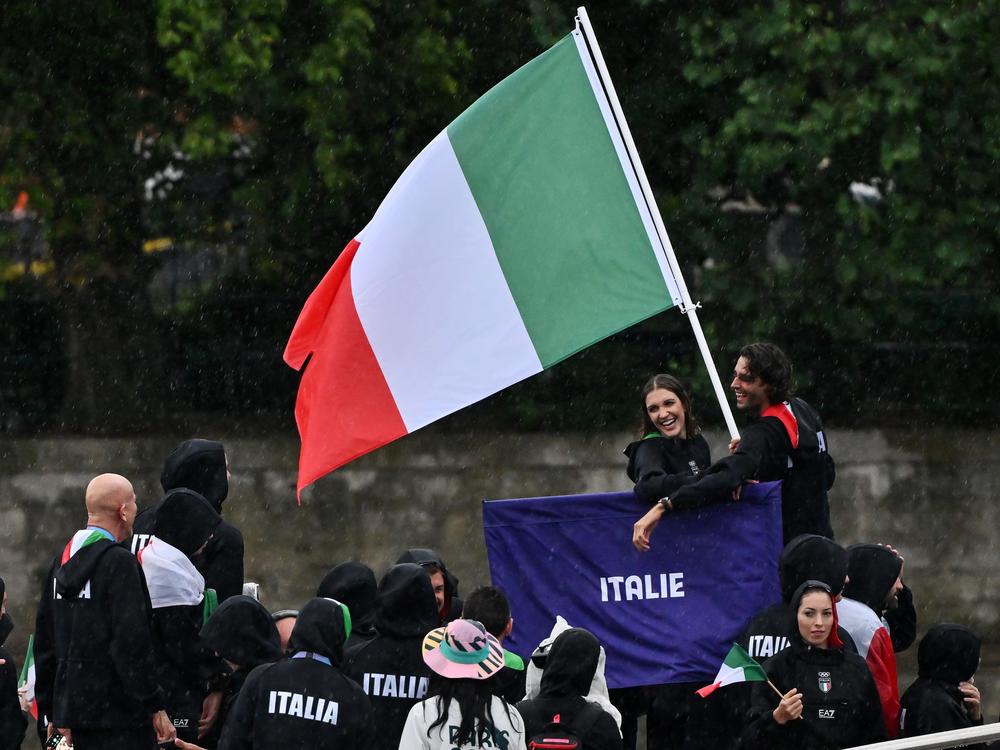 Italy athletes aboard a boat in the floating parade on the river Seine.