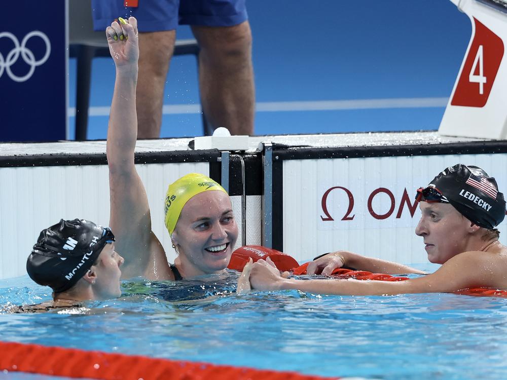 Ariarne Titmus of Team Australia celebrates after winning gold as Canada's Summer McIntosh (left) and USA's Katie Ledecky (right) win silver and bronze in the Women's 400m Freestyle Final on Saturday at Paris La Defense Arena in Nanterre, France.