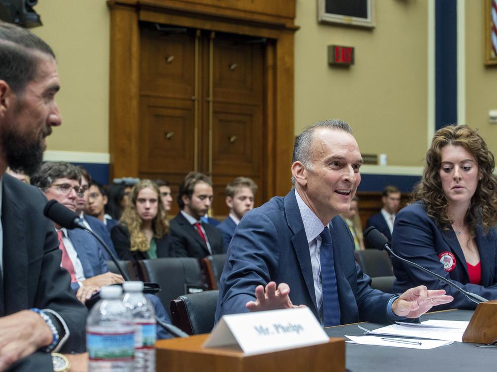 Former Olympic athletes Michael Phelps (left) and Allison Schmitt (right), listen as Travis Tygart, CEO of the U.S. Anti-Doping Agency, center, testifies during a Congressional hearing examining Anti-Doping Measures in Advance of the 2024 Olympics, on Capitol Hill, Tuesday, June 25, 2024, in Washington.