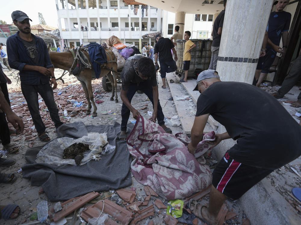 Palestinians search for bodies in the rubble of a school destroyed in an Israeli airstrike on Deir al-Balah, central Gaza Strip, Saturday.