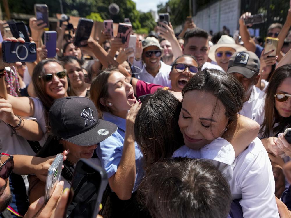 Opposition leader Maria Corina Machado hugs supporters after voting in the presidential election in Caracas, Venezuela, Sunday, July 28, 2024. 