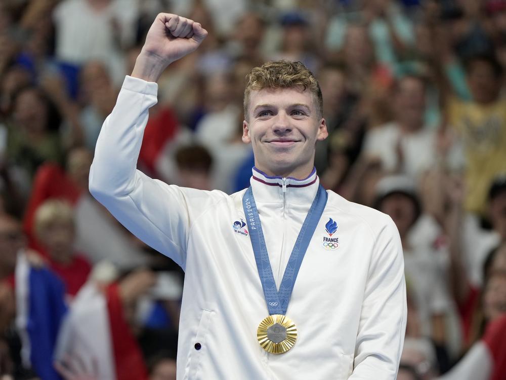 Leon Marchand, of France, celebrates after receiving his first gold medal in the men's 400-meter individual medley final at the 2024 Paris Summer Olympics on Sunday in Nanterre, France.