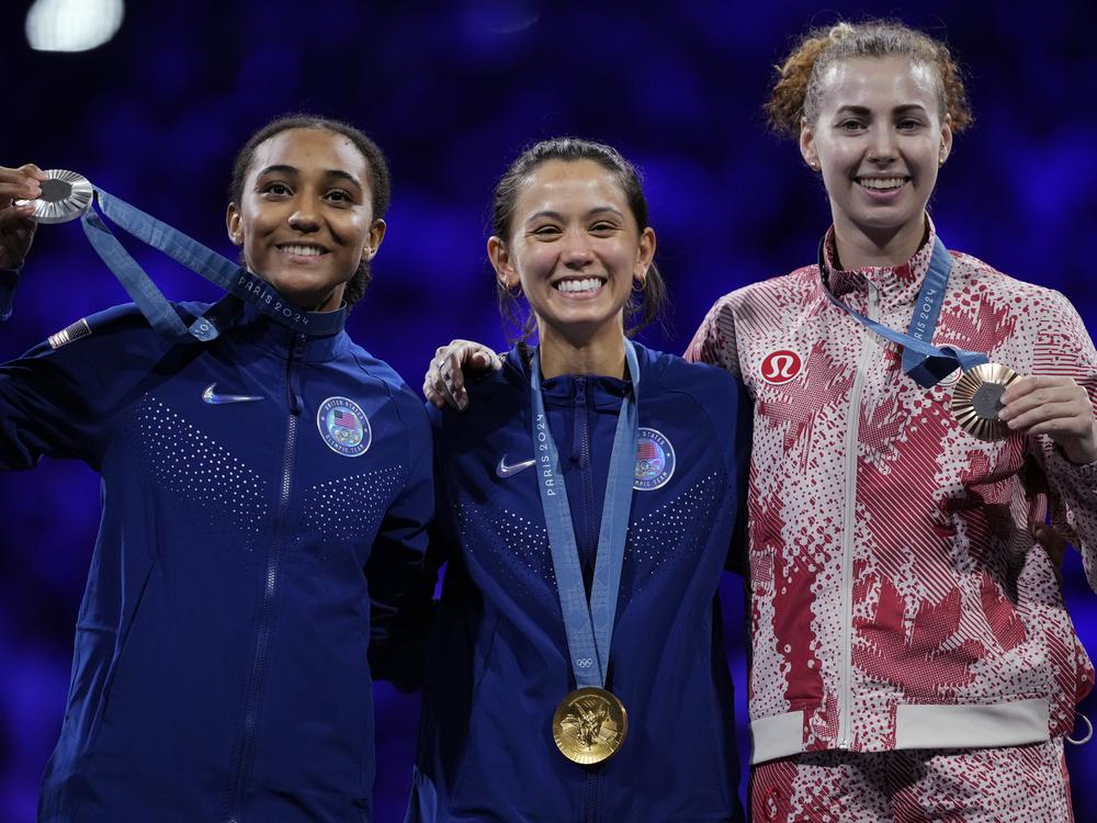 United States' Lee Kiefer, center, winner of the gold medal of the women's individual Foil competition, celebrates on the podium with silver medal winner United States' Lauren Scruggs, left, and bronze medal winner Canada's Eleanor Harvey during the Paris Olympics on Sunday.