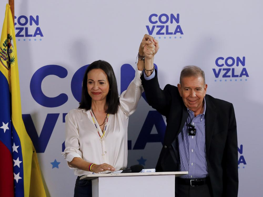 Opposition presidential candidate Edmundo Gonzalez (right) and opposition leader María Corina Machado join hands during a press conference the day after the election in Caracas, Venezuela, Monday.