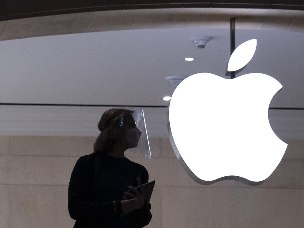 An Apple store employee stands inside the store in New York on Feb. 5, 2021. 