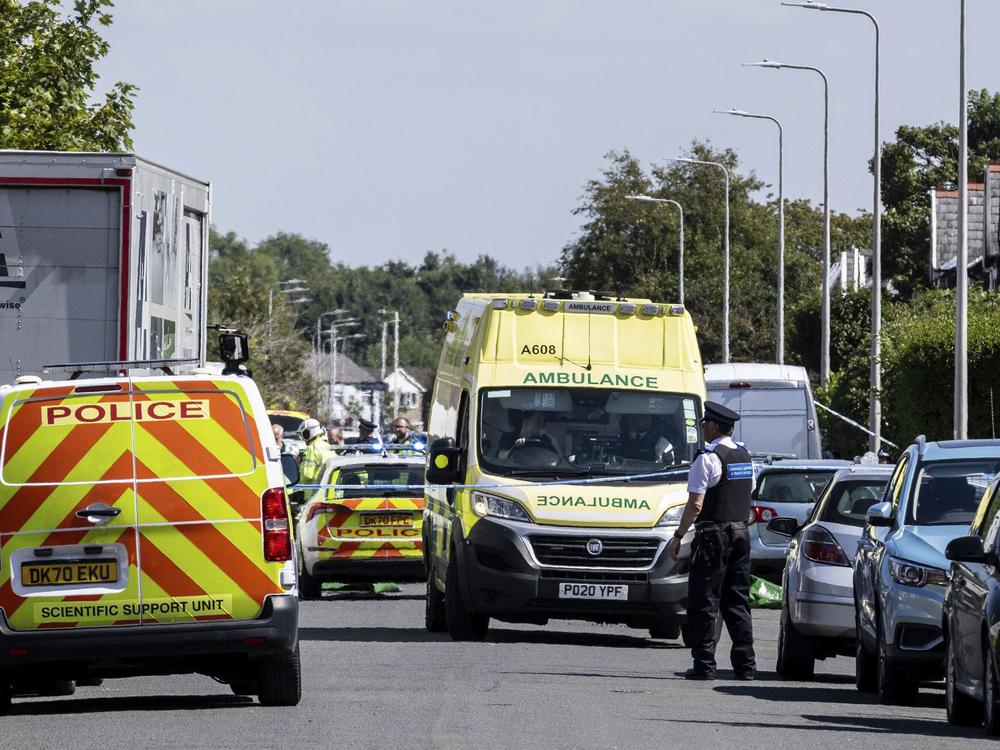 Emergency services work at the scene in Southport, England, where a man has been detained and a knife has been seized after a number of people were injured in a reported stabbing on Monday.