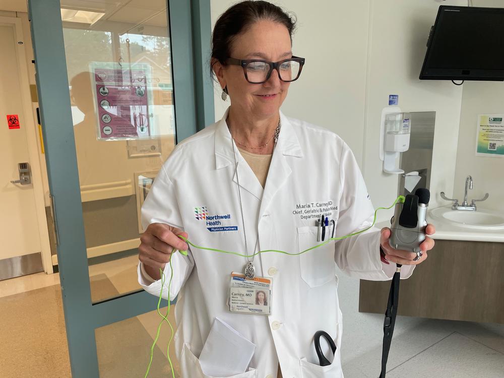 Dr. Maria Carney holds an assisted hearing device that can be used to help older adults communicate in the ER. Patients often come to the emergency department without their hearing aids or glasses, compounding their confusion in a stressful place.