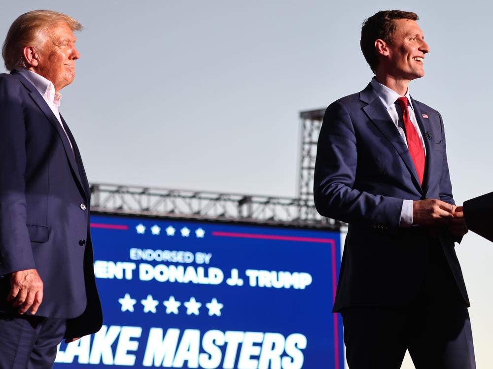 Former President Donald Trump, seen here on October 9, 2022, in Mesa, Ariz., previously backed Blake Masters, right, in a Senate bid he ultimately lost. Trump's now offering dual endorsements to Masters and  Abe Hamadeh, his primary challenger in a House race.