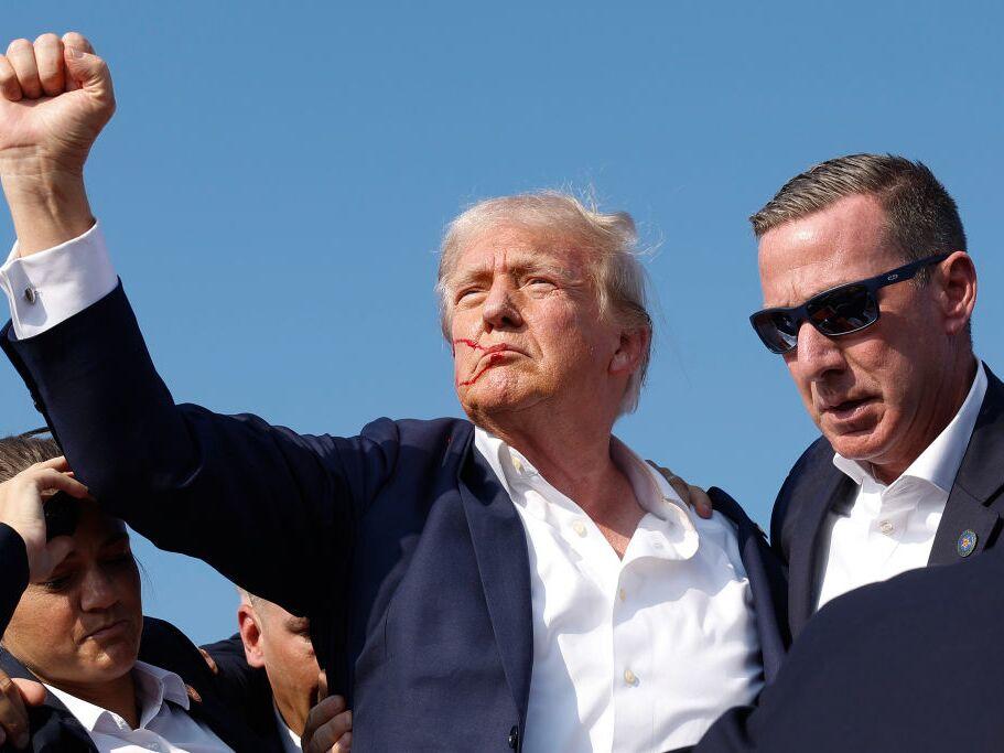 Former President Trump pumps his fist as he is rushed offstage during a rally on July 13, 2024, in Butler, Pa.