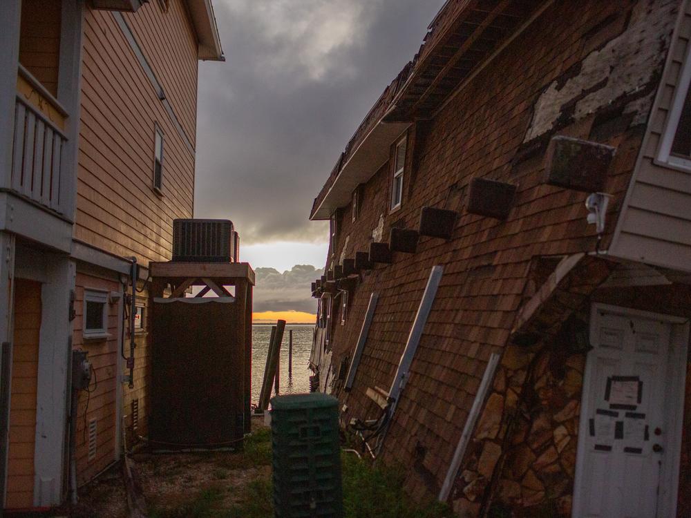 A building lists towards the water along Big Pine Island Road in Matlacha, Fla., as the sun sets in June. In the last 5 years, the number of weather disasters that caused at least 1 billion dollars of damage has skyrocketed, causing hundreds of billions of dollars of damage.