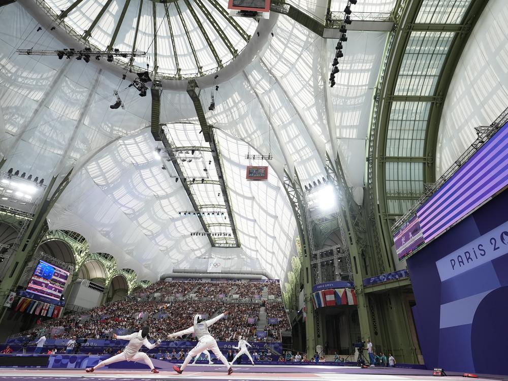China's Huang Qianqian, left, competes with United States' Lauren Scruggs in the women's team foil quarterfinal on Thursday at the 2024 Paris Olympics.