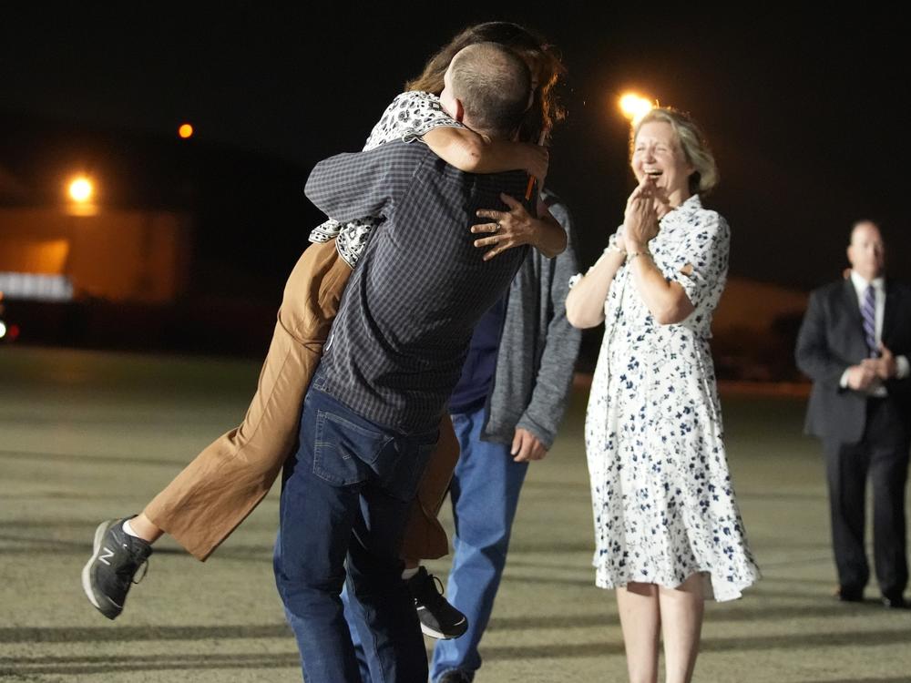 Reporter Evan Gershkovich hugs his mother Ella Milman, left, at Joint Base Andrews, Md., following his release as part of a 24-person prisoner swap between Russia, the U.S. and several other countries on Thursday. Looking on at right is Elizabeth Whelan, sister of released prisoner Paul Whelan.