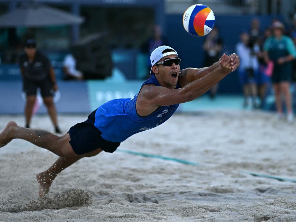 Brazil's Arthur Diego Mariano Lanci dives to return the ball in a beach volleyball match between Brazil and Austria during the Paris 2024 Olympic Games at the Eiffel Tower Stadium on Sunday.