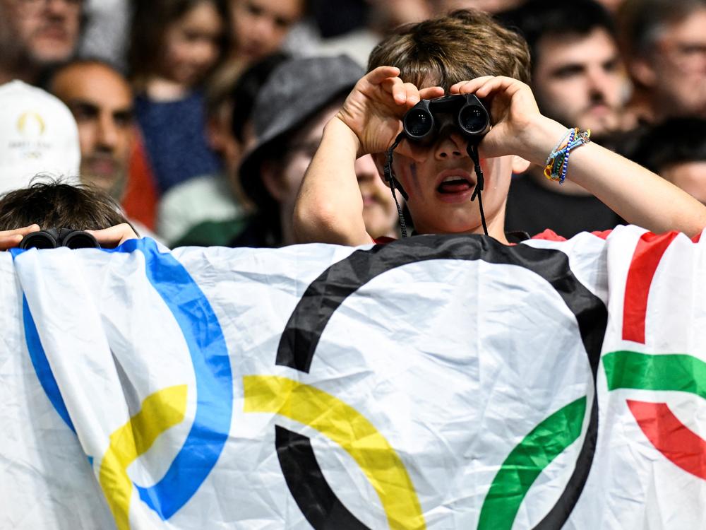 Two children look through their binoculars at the men's table tennis singles round of 64 at the South Paris Arena on Saturday.