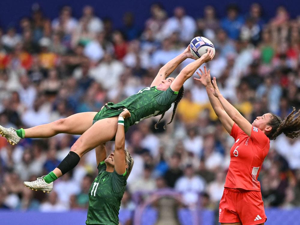 Ireland's Emily Lane (center) catches the ball in a line-out above Ireland's Erin King (down) as they're challenged by Britain's Lauren Torley (right) during the women's placing 7-8 rugby sevens match Tuesday.