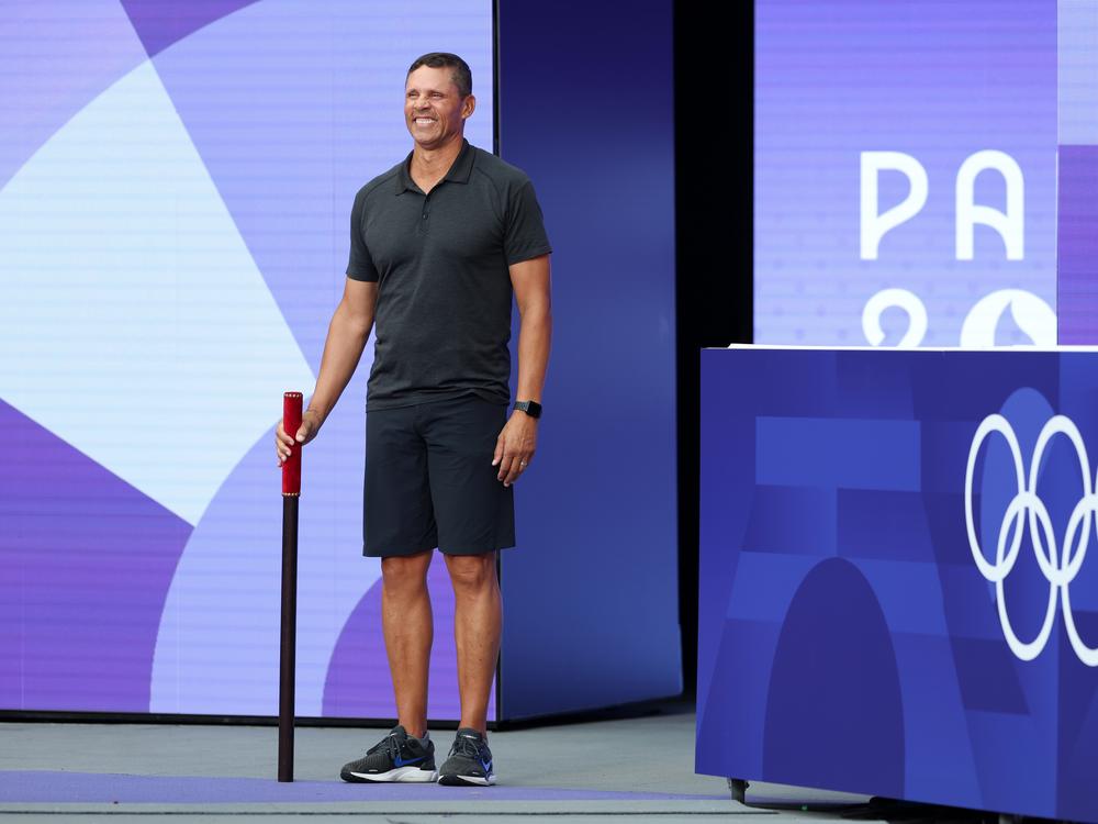 Dan O'Brien, a former American decathlete, bears the brigadier ahead of the High Jump portion of the Decathlon at Stade de France on Friday. He's about to command the attention of the stadium's raucous crowd as part of a new, very French Olympic custom.