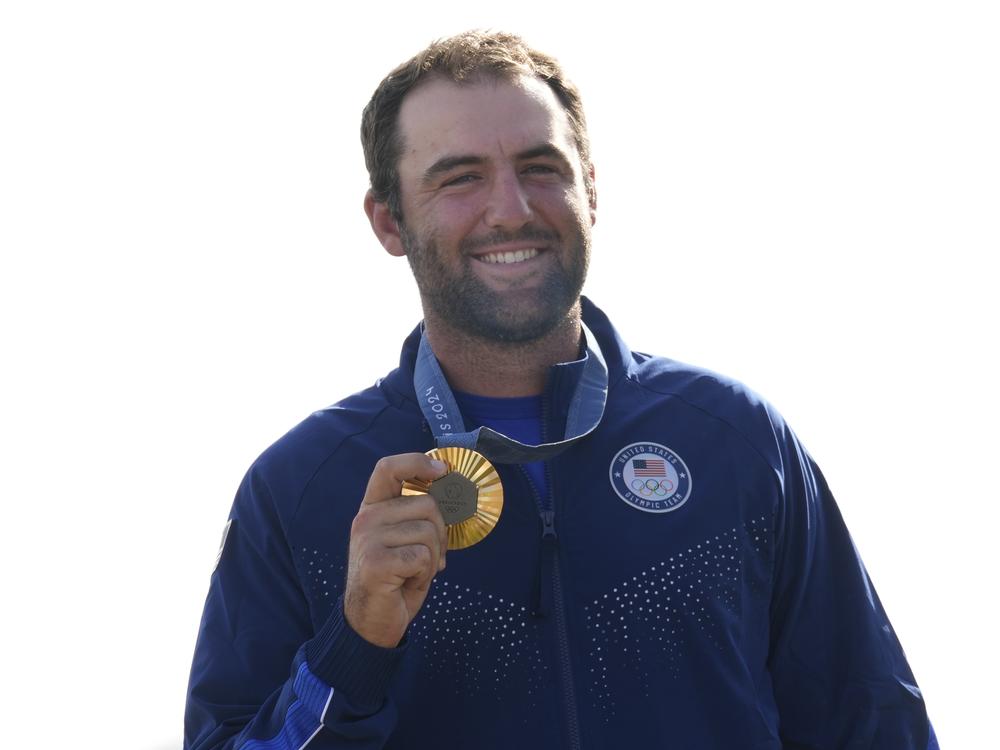 Gold medalist Scottie Scheffler, of the United States, poses with his medal following the medal ceremony for men's golf during the medal ceremony at the 2024 Summer Olympics on Sunday, Aug. 4.