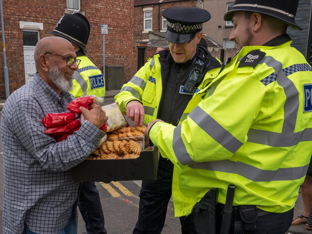 Food and snacks are offered to police officers by local residents as they stand on a police line while far-right activists hold a demonstration in Middlesbrough, England on Sunday.