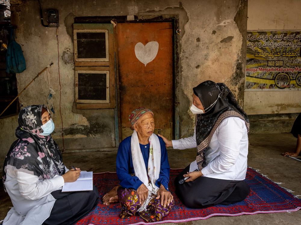 Two health workers see a patient.  “Cataract cut my main income source,