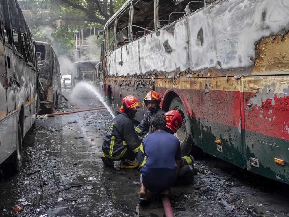 Firefighters and people work to douse a fire that broke out and burnt several vehicles at Bangabandhu Sheikh Mujib Medical University on August 4.