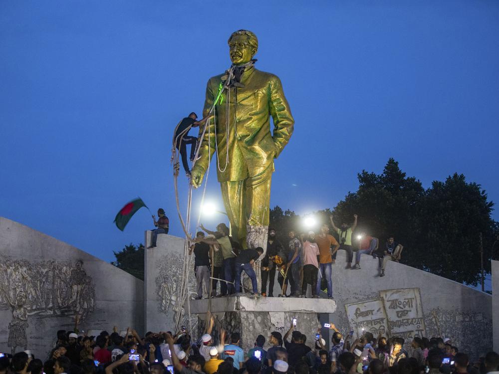 Protesters try to demolish a large statue of Sheikh Mujibur Rahman, father of Bangladesh leader Sheikh Hasina, after she resigned as Prime Ministe on August 5.