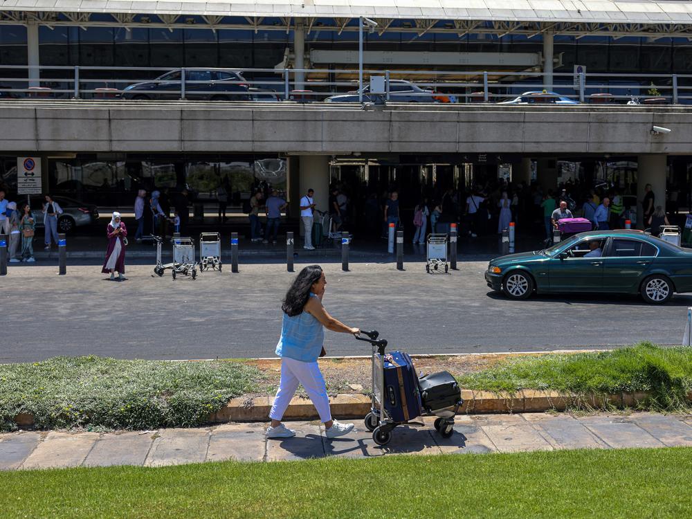 A passenger pushes a loaded trolley outside the departures' terminal at Rafic Hariri International Airport in Beirut on July 29.