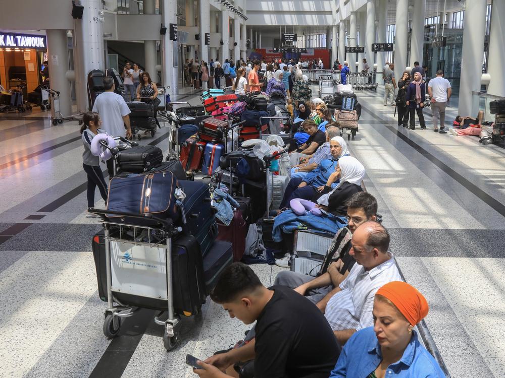 People await their flights at the Beirut International Airport departure hall on Monday. Urgent calls grew for foreign nationals to leave Lebanon, which would be on the front line of a regional war, as Iran and its allies readied their response to high-profile killings blamed on Israel.