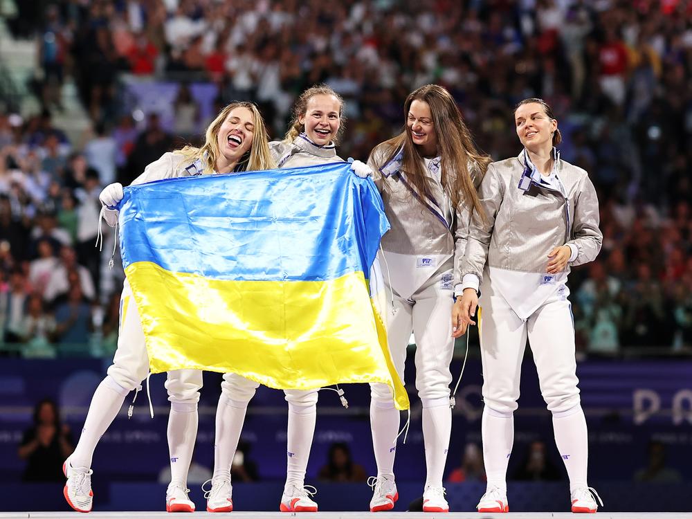 Olga Kharlan, Yuliia Bakastova, Olena Kravatska and Alina Komashchuk of Ukraine celebrate following their gold medal win in the women's saber finals.