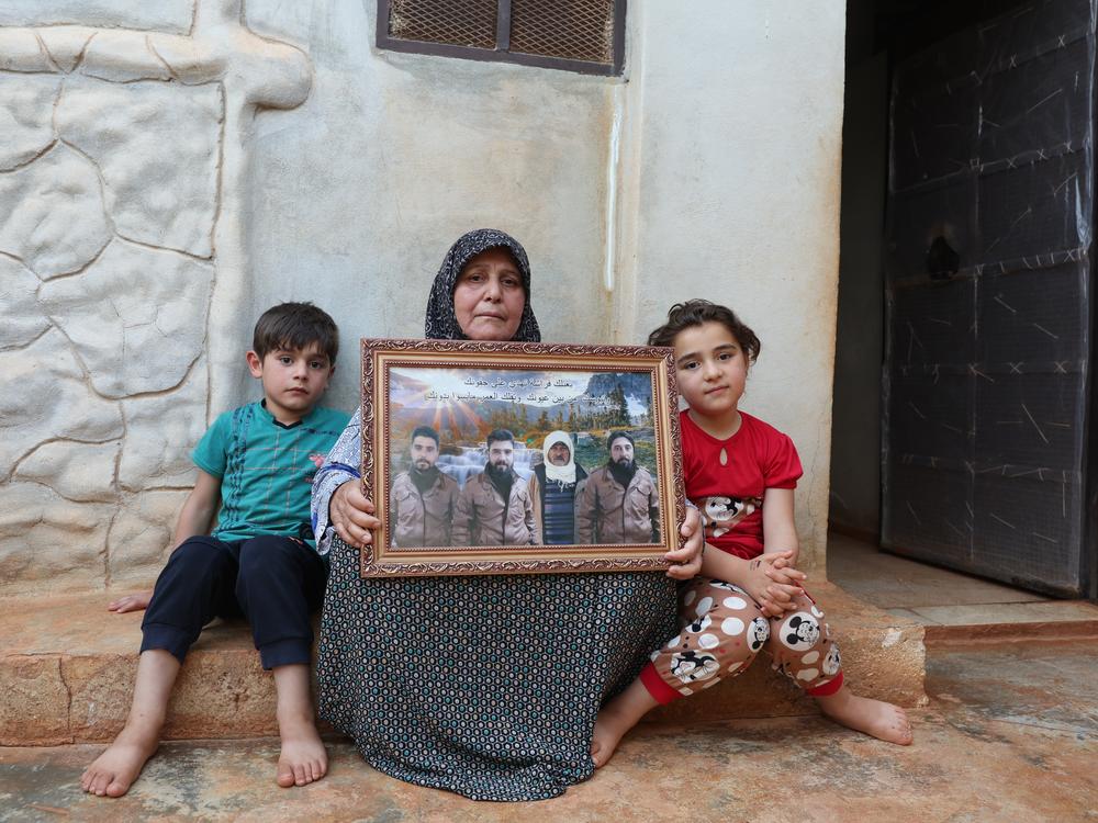 Fatima Qurmo holds a photo that includes her late son, Khaled Abdel Majid Qurmo, in the Syrian village of Turlaha on June 24, 2023. The Pentagon says it's investigating NPR reports of accounts that her son and his cousin were killed by U.S. airstrikes during the 2019 raid targeting ISIS leader Abu Bakr al-Baghdadi.