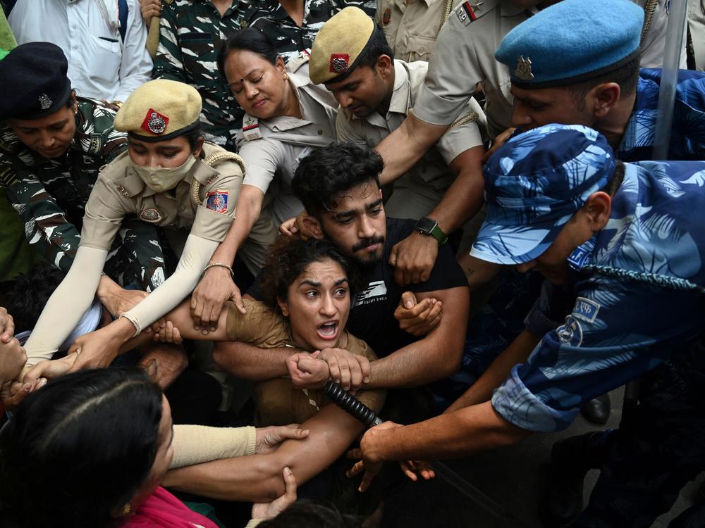Vinesh Phogat (center) and other elite Indian wrestlers were detained by the police in New Delhi last year as they protested against Brij Bhushan Singh, who was then the wrestling federation chief, over allegations of sexual harassment and intimidation.