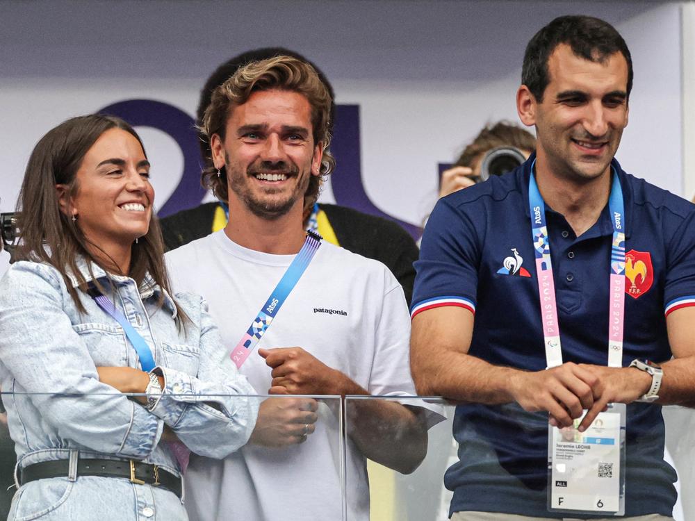 Athletico Madrid's French soccer player Antoine Griezmann, his wife Erika Choperena, and French Rugby Federation CEO Jeremie Lecha attend the men's gold medal rugby sevens match between France and Fiji during the Paris Olympics in Saint-Denis last month.