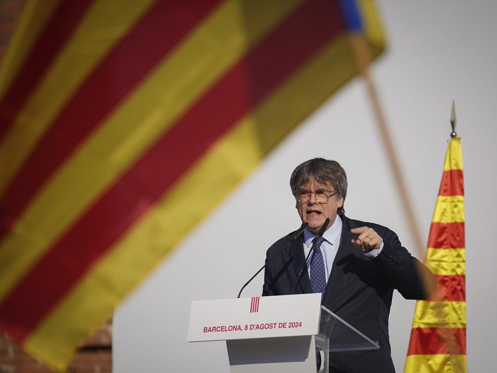 Catalan independence leader and former President Carles Puigdemont addresses supporters after his arrival near the Catalan Parliament to attend the investiture debate in Barcelona, Spain, Thursday.