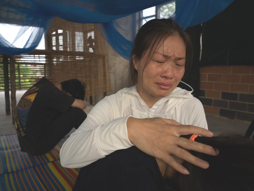 Liu Fengling comforts her daughter and son in Bangkok after spending four months in detention.
