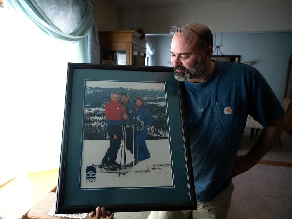 Casey Shively holds a photo of a family ski trip with his sister, Katie, and his father, Dan, in 1996. Dan Shively died in a memory care home after being violently attacked by another resident.