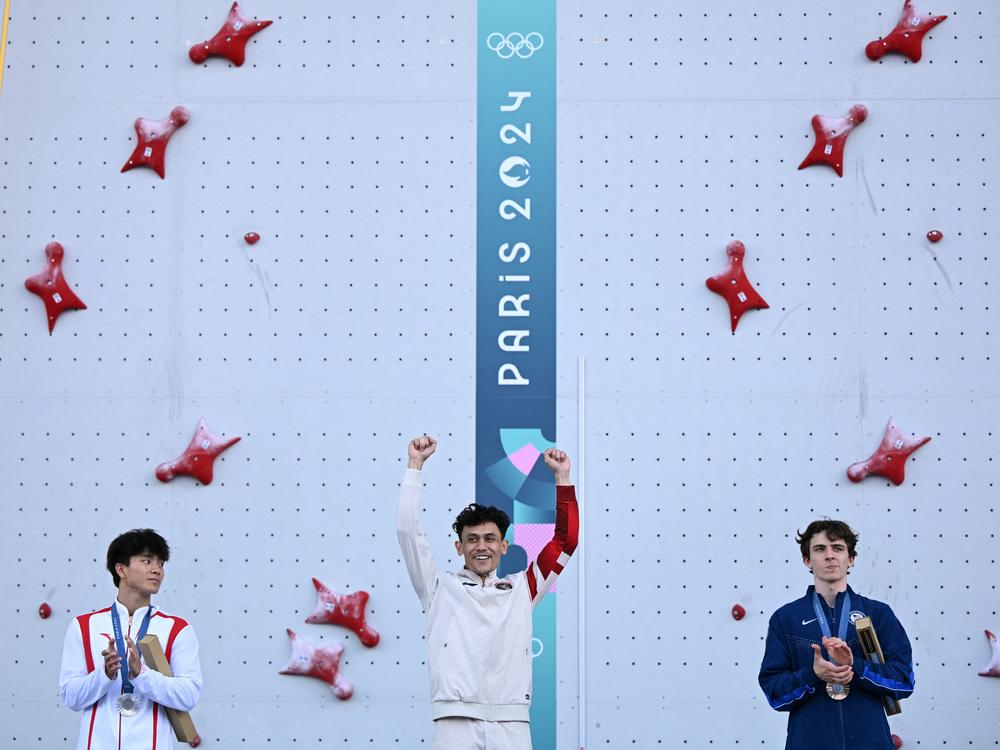 Gold medalist Indonesia's Veddriq Leonardo (center), silver medallst China's Wu Peng (left) and bronze medalist UsA's Sam Watson (right) pose on the podium of the men's sport climbing speed event during the Paris Olympics at the Le Bourget Sport Climbing Venue northeast of Paris.