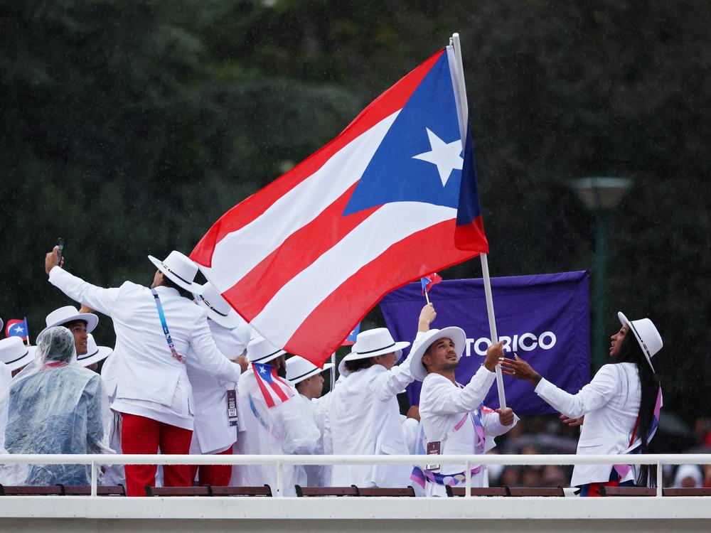 Athletes of Team Puerto Rico are seen on a boat on the River Seine during the opening ceremony of the Olympic Games in Paris on July 26.