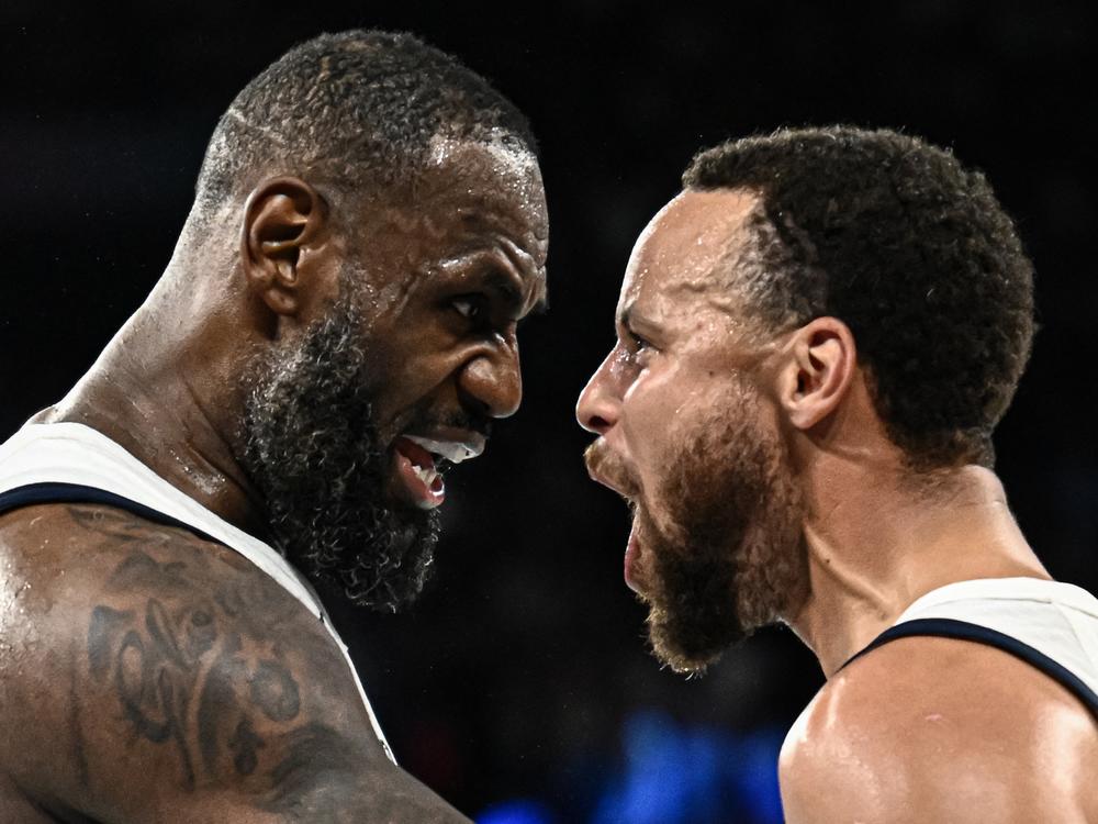 USA's LeBron James (L) celebrates with StephCurry at the end of their semifinal basketball game against Serbia. The U.S. edged Serbia 95-91 and will play France in the gold medal game.