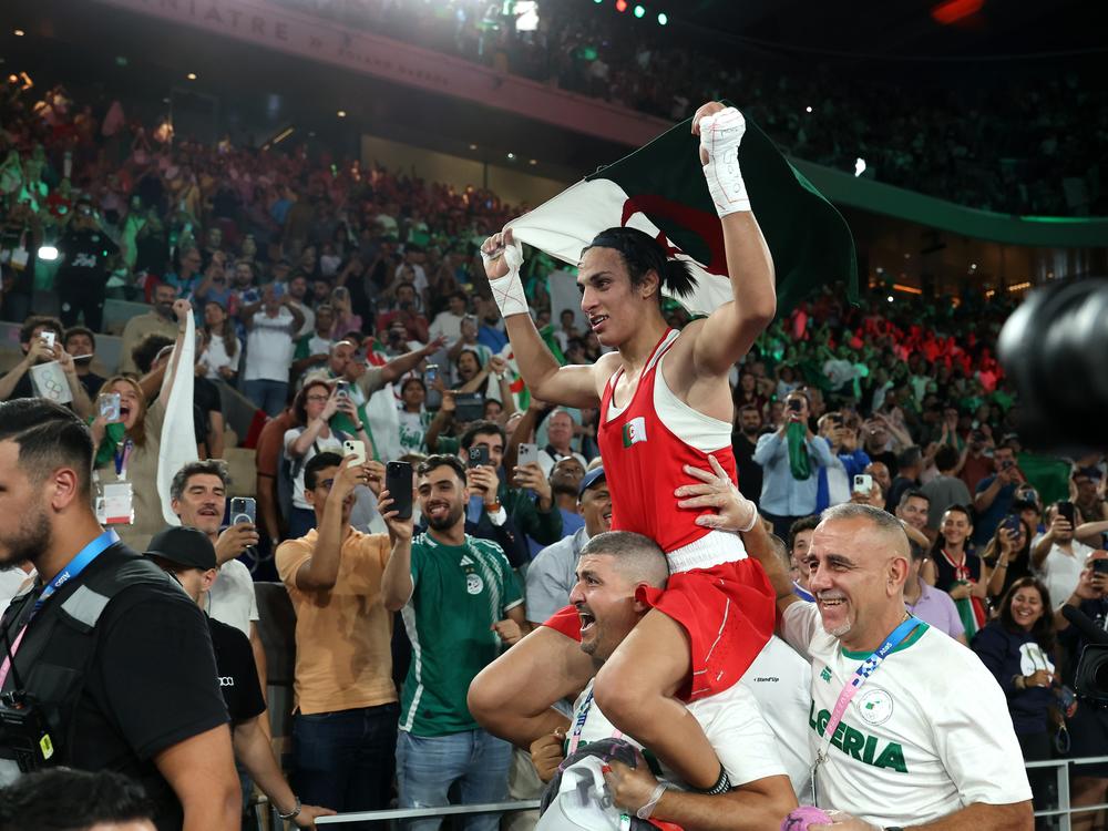 Algeria's Imane Khelif celebrates winning the gold medal with her coaches Mohamed Chaoua and Mohamed Al-Shawa after the Boxing Women's 66kg final against Liu Yang of China on Friday.
