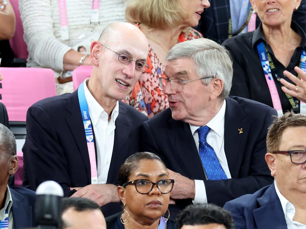 NBA Commissioner Adam Silver (L) and IOC President Thomas Bach speak during Saturday's men's gold medal basketball game between France and United States.